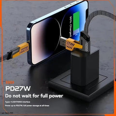 Smartphone charging via a USB cable and adapter on a textured surface with text indicating power specifications.