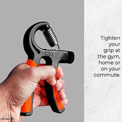Hand holding a black and orange grip strengthener against a gray background