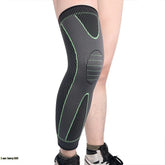 Black and green knee brace on a person's leg against a white background