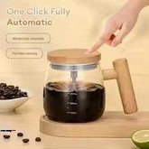 Coffee maker with wooden handle on a wooden surface, surrounded by coffee beans and a lime.