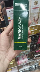 Hand holding a Markaway stretch mark serum packaging in a store setting