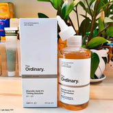The Ordinary skincare product on a wooden surface with a plant in the background